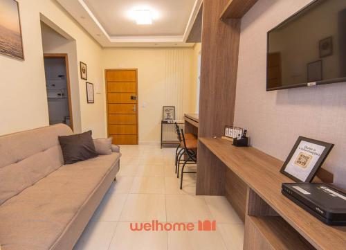 un salon avec un canapé et une télévision à écran plat dans l'établissement Apartamento na Praia Grande a 500m Praia do Forte, à Praia Grande