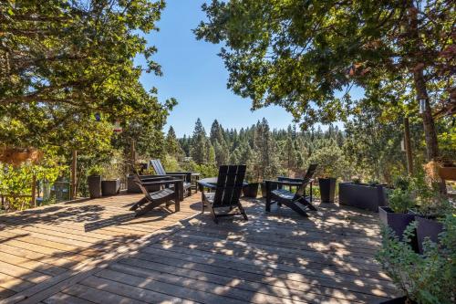 una terraza con mesa, sillas y árboles en Happenstance Vineyards home, en Lyle