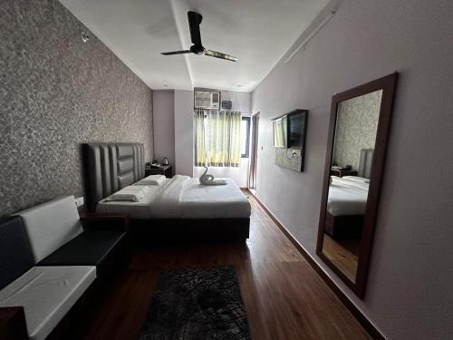 a bedroom with a bed and a mirror and a couch at Hare Rama Guest House in Dehradun