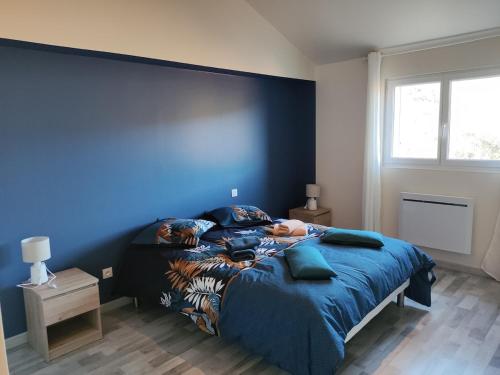 a bedroom with two beds and a blue wall at Villa Les Combes avec piscine chauffée in Proissans