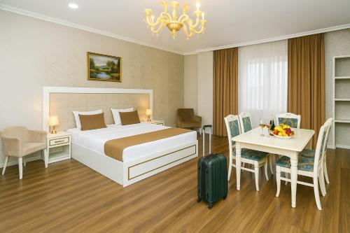 a hotel room with a bed and a table with a suitcase at Maris Hotel Baku in Baku