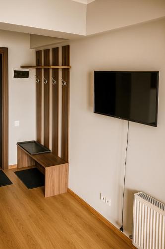 Una habitación con un televisor de pantalla plana en una pared. en Alpine Vista Gudauri, en Gudauri