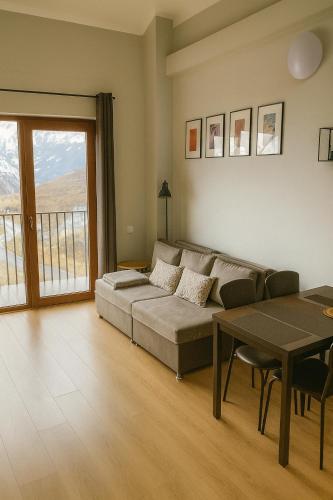 una sala de estar con un sofá y una mesa en Alpine Vista Gudauri, en Gudauri