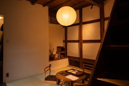 a dining room with a table and a lamp at Tokinoma ときのま in Kawagoe