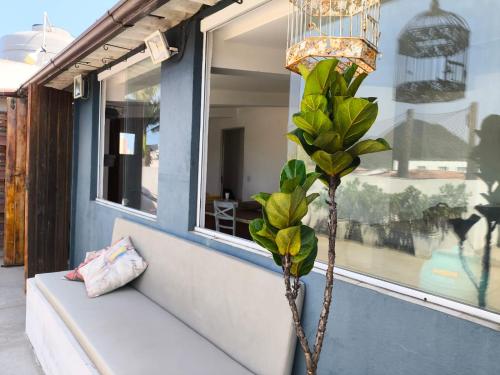 a plant sitting on a bench next to a window at Cobertura na Praia Grande in Praia Grande