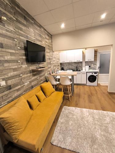 a living room with a yellow couch and a kitchen at Share Relax & Get Better in Veliko Tŭrnovo