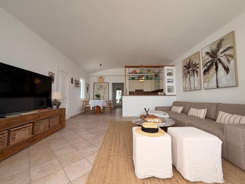 a living room with a couch and a flat screen tv at Villa Atenea by Aura Villas in Charco del Palo