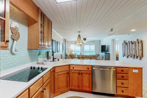 a kitchen with wooden cabinets and a stainless steel dishwasher at Pinnacle Port C2-404 in Panama City Beach
