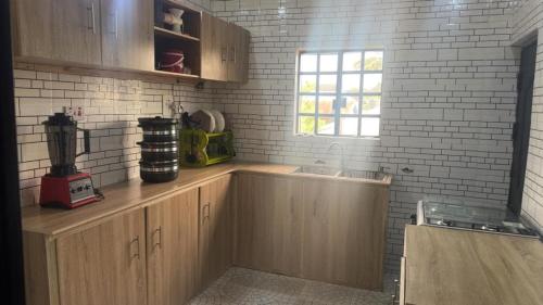 ベニンシティにあるShort Let Apartment in Benin City- Hosted By Tomlaの木製のキャビネットとシンクと窓のあるキッチン