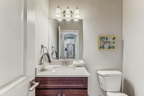 Un baño con lavabo, inodoro y espejo. en Zion Village Family Escape, en Hurricane