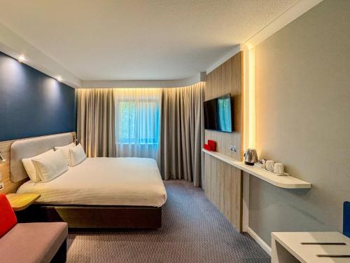 a hotel room with a bed and a couch at Holiday Inn Express London Stratford by IHG in London