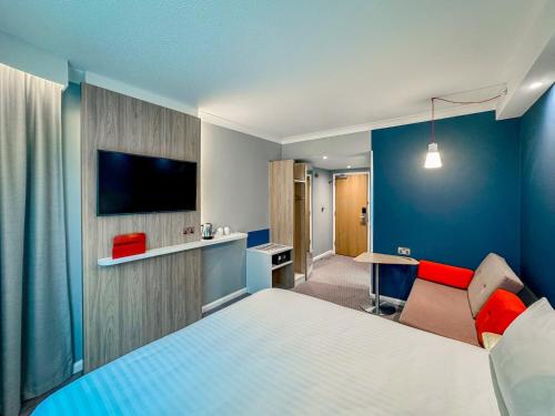 a hotel room with a bed and a tv at Holiday Inn Express London Stratford by IHG in London