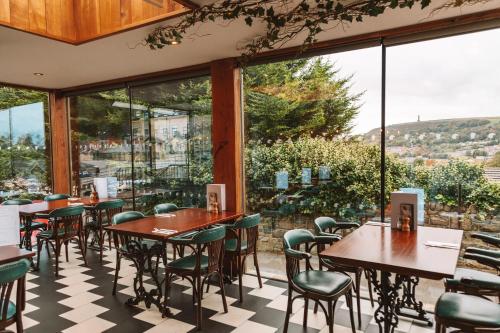 a restaurant with tables and chairs and large windows at Eagle and Child, Ramsbottom in Bury