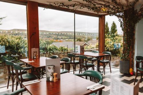 a restaurant with tables and chairs and a large window at Eagle and Child, Ramsbottom in Bury