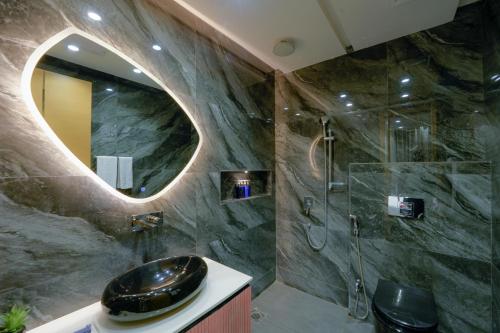 a bathroom with a sink and a shower with a mirror at La Maison Royale Hotel in Lahore