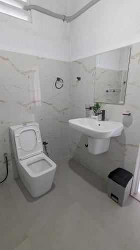 Un baño blanco con inodoro y lavabo. en Sea View Villa, Galle, en Galle