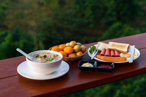 a table with a bowl of soup and a plate of food at บ้านสวนเอลเลน in Ban Huai Khai