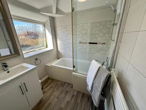 a bathroom with a shower and a sink and a tub at Family-Friendly 4BR Home in Sale, Manchester - Garden & Double Driveway in Sale