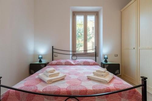 a bedroom with a bed with two towels on it at Illy House Apartment in Alghero