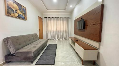 a living room with a couch and a flat screen tv at Apartamento Região Central de Foz do Iguaçu 3 in Foz do Iguaçu