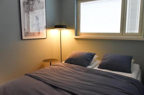 1 dormitorio con 1 cama con ventana y lámpara en Penthouse Kemi, en Kemi