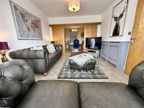 a living room with leather couches and a flat screen tv at Luxury Pet-Friendly 2 Bed Retreat in Central Bowness with Copper Roll-Top Bath & Sun Terrace in Bowness-on-Windermere
