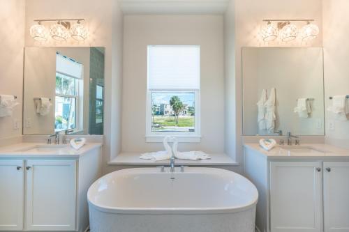 een witte badkamer met een bad en 2 wastafels bij Tranquil Daze by Sun Palace Vacations in Fort Myers Beach