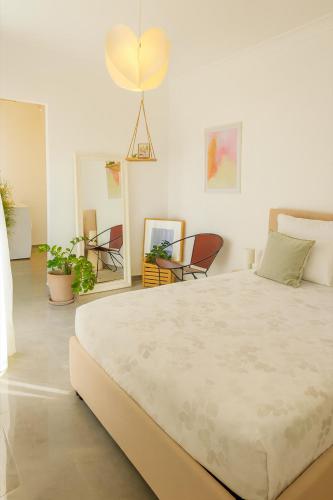 a bedroom with a large white bed and chairs at Sunny Penthouse with Large Terrace in Marsaxlokk