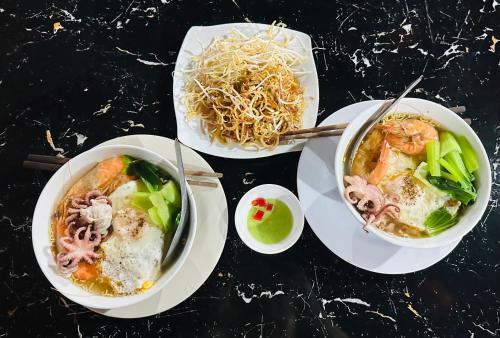 three bowls of food on a table with noodles at Nhà Nghỉ Đại Lý Bình Châu in Xuyên Mộc