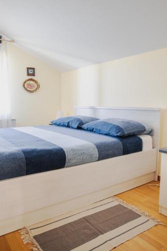 a bedroom with a bed with blue pillows on it at Green Zelina in Šulinec