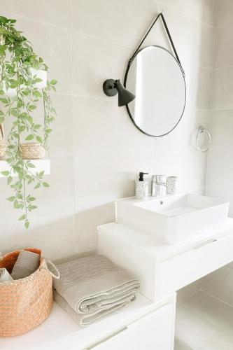 a bathroom with a white sink and a mirror at Sunny Penthouse with Large Terrace in Marsaxlokk