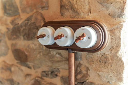 a switch on a stone wall with four lights at El Apartamentín de Verdiago in Verdiago