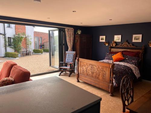 a bedroom with a bed and a large sliding glass door at Williams Cottage A High end little home with antique style in Tarporley