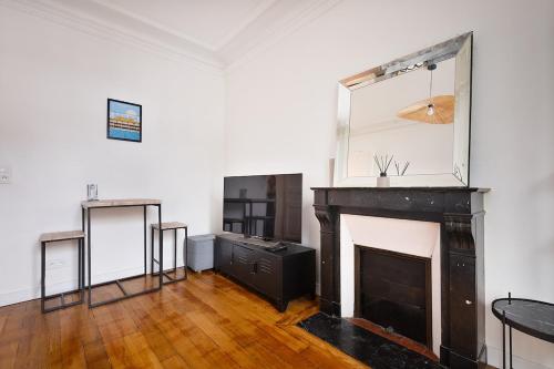 an empty room with a fireplace and a mirror at Parisian Apartment for 3 People - Paris Parc des Princes WiFi & Metro in Boulogne-Billancourt