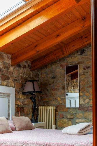 a bedroom with a stone wall with a bed at El Refugio I de Verdiago in Verdiago