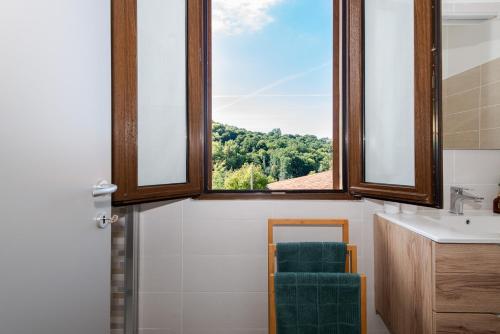 a bathroom with a window and a sink and a mirror at La casa nel verde di Francesco in Lipomo