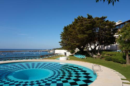 a swimming pool with a checkerboard pattern on it at Hotel do Mar in Sesimbra