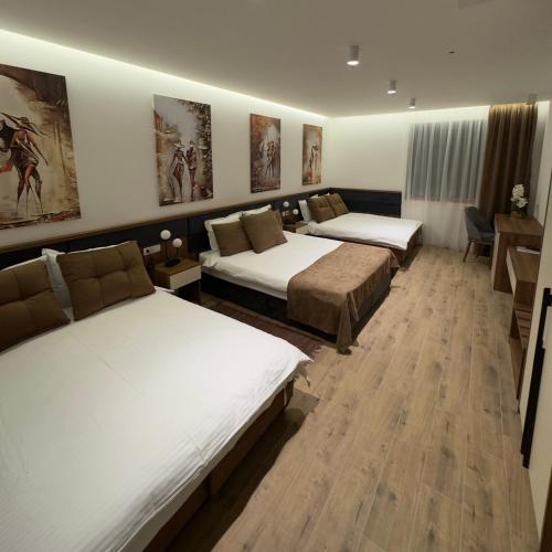 a hotel room with three beds in a room at Motel Krnjevo OAZA in Krnjevo