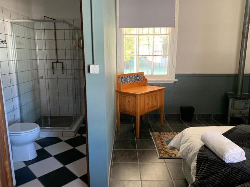 Un baño con lavabo, inodoro y ducha. en Ticket Offices, en Calitzdorp