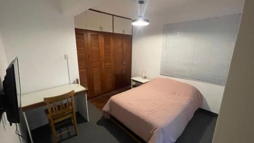 a bedroom with a bed and a desk and a chair at miralfores lighthouse in Lima