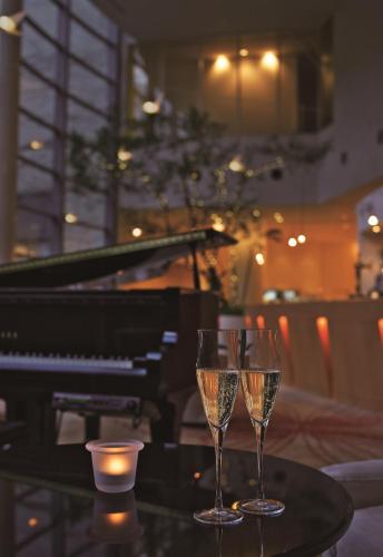 two glasses of champagne on a table next to a piano at GRAND NIKKO AWAJI in Awaji