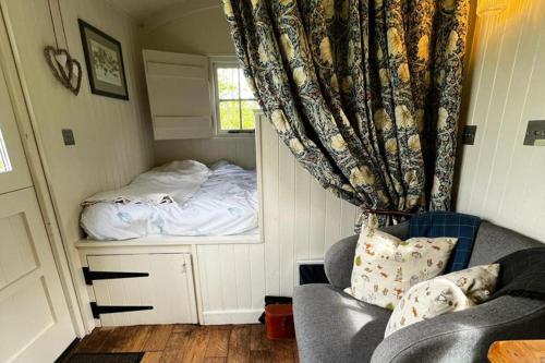 una camera da letto con un letto, un divano e una finestra di 1 Bed Glamping Hut - Firepit Fireplace Views a Newcastle upon Tyne