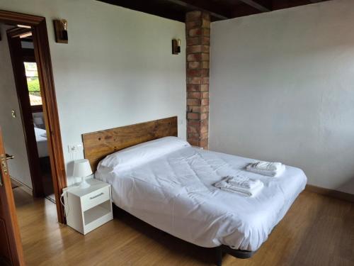 a bedroom with a bed with white sheets at Apartamentos Dani Llanes in Posada de Llanes