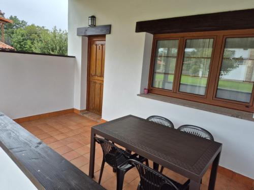 a dining room with a table and chairs and a window at Apartamentos Dani in Posada de Llanes