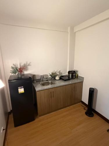 a small kitchen with a sink and a refrigerator at Le Nomad Homestay in Batangas City