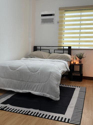 a bedroom with a bed with a black and white comforter at Le Nomad Homestay in Batangas City
