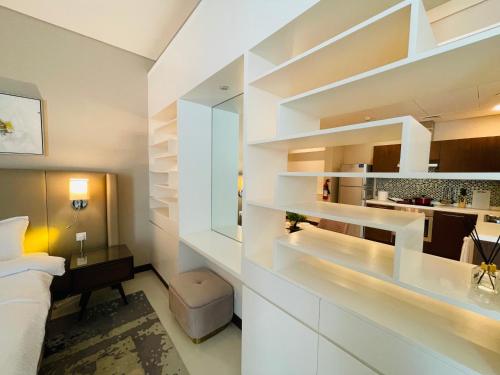 ein Schlafzimmer mit einem Bett und einem Schreibtisch in einem Zimmer in der Unterkunft Modern comfort in a compact spacious studio one or two bedroom retreats in Manama