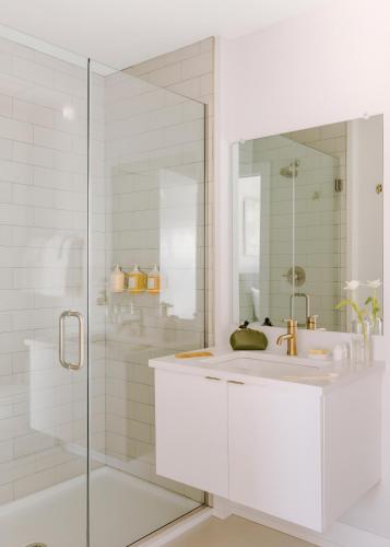 a white bathroom with a sink and a shower at Sosuite at The Ovation - Ave of The Arts in Philadelphia