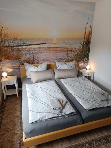 a bedroom with a bed with a painting of the ocean at FeWo & Dz "Am Wald" in Altheide
