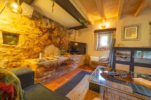 a living room with a stone wall at La Pause noble val in Saint-Antonin-Noble-Val